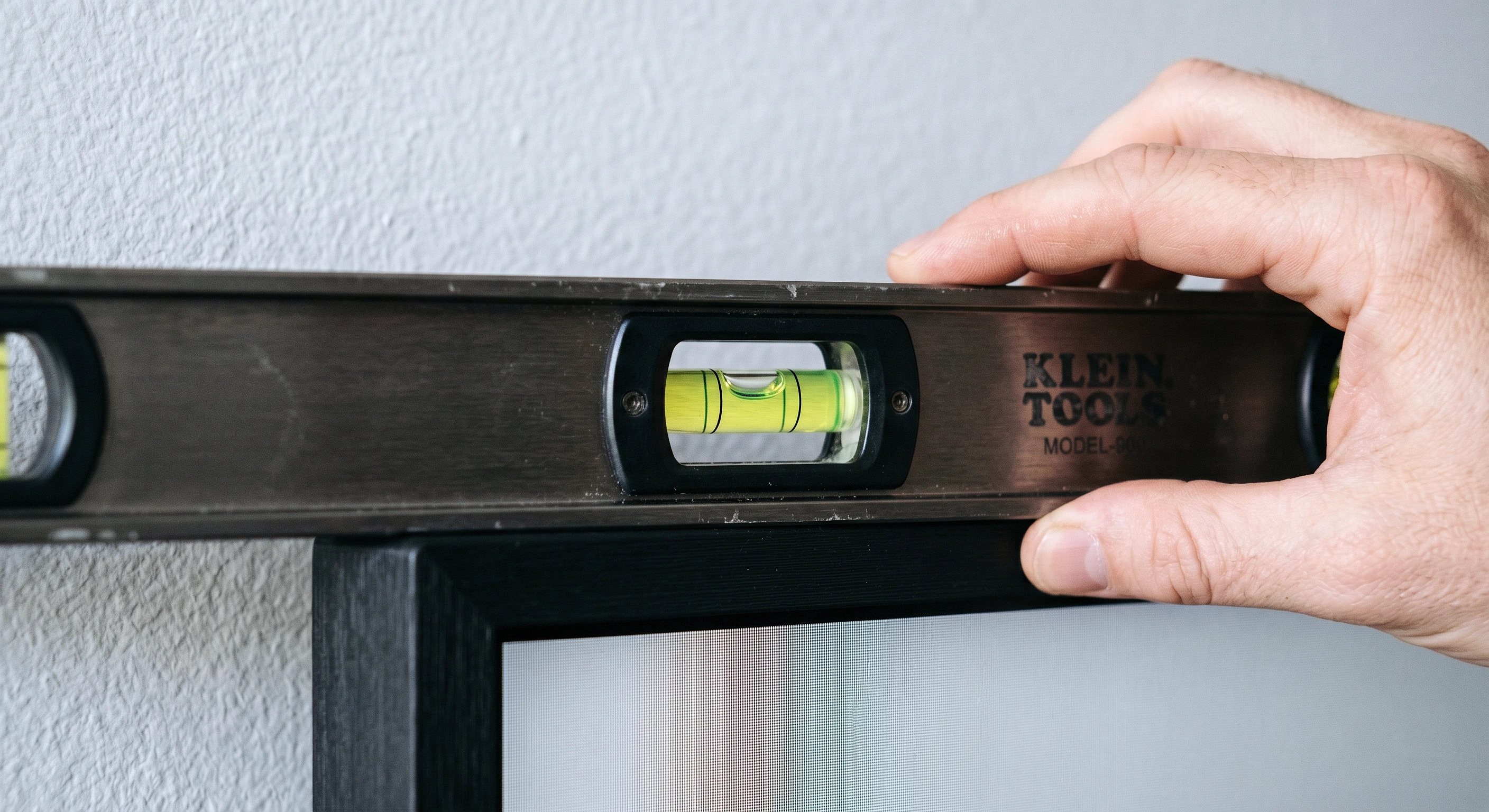 Professional TV mounting precision level check in Frisco, Texas