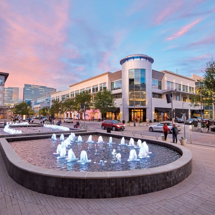 Shops at Legacy fountain plaza at sunset in Plano, TX